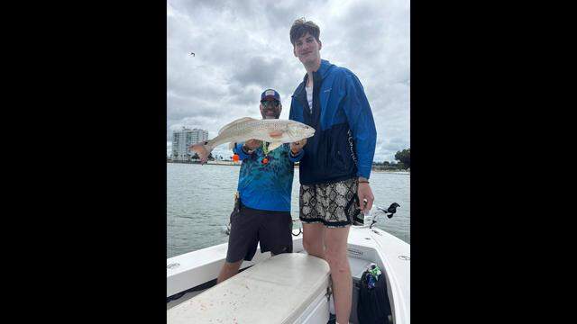 7-foot, 9-inch University of Florida basketball player Olivier Rioux poses for a photo with Rob Chapman during an April 7 fishing trip in Tampa Bay.